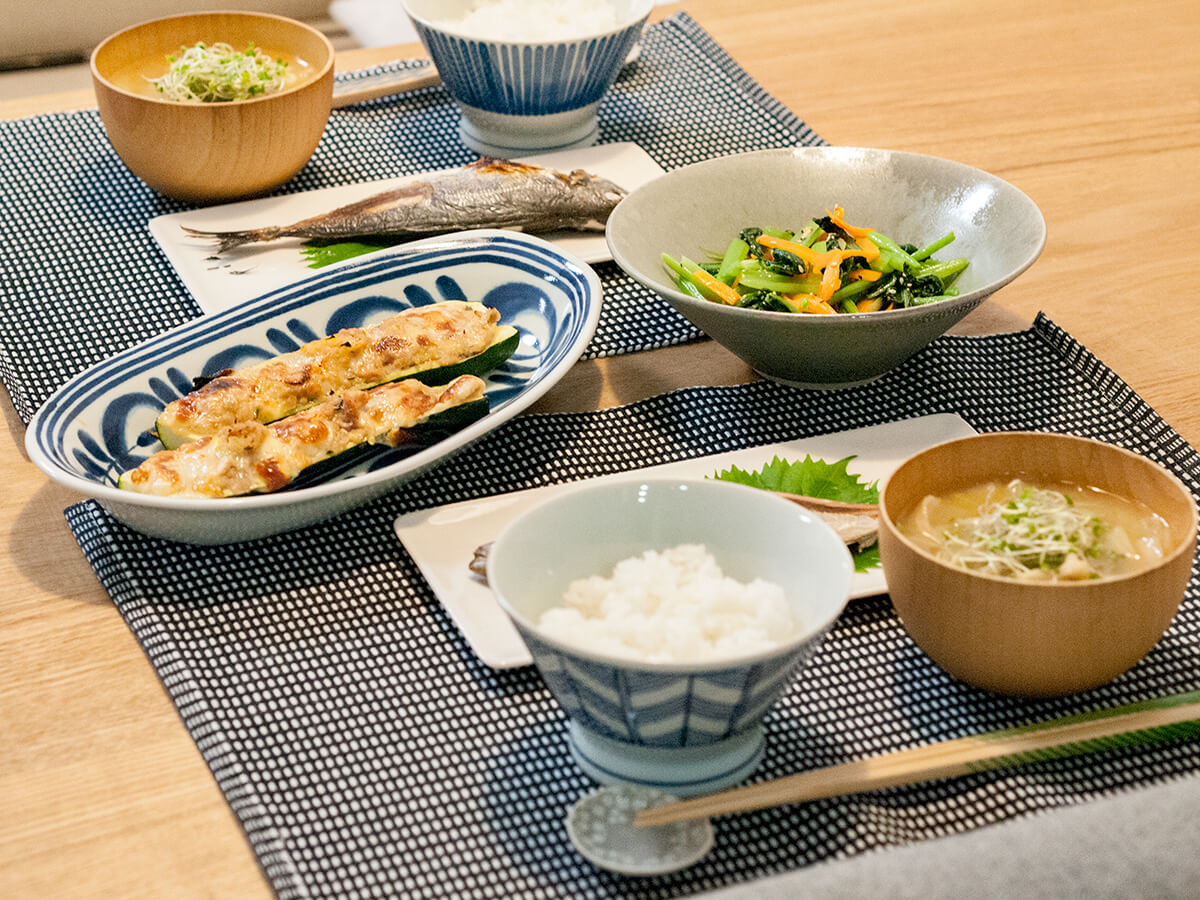 焼き魚とズッキーニのグラタンと小松菜のナムルが並ぶ食卓